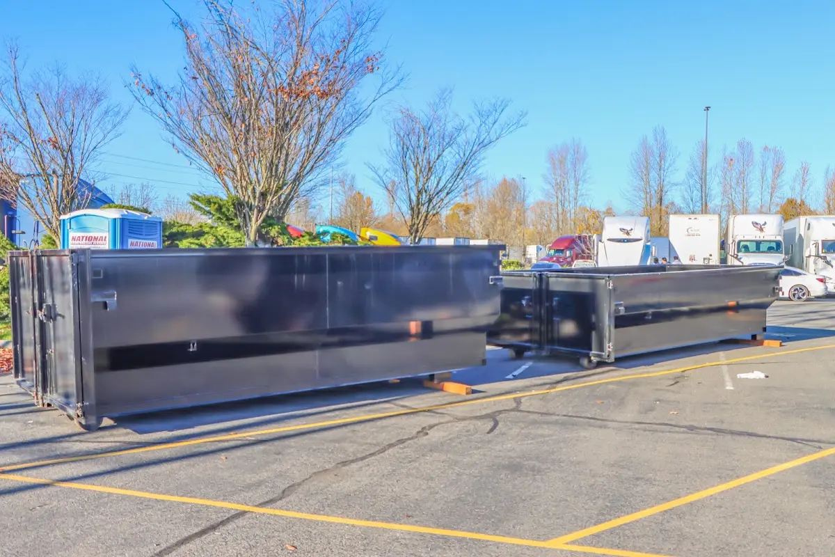 Professional dumpster rental service with roll-off container on residential driveway in Tea